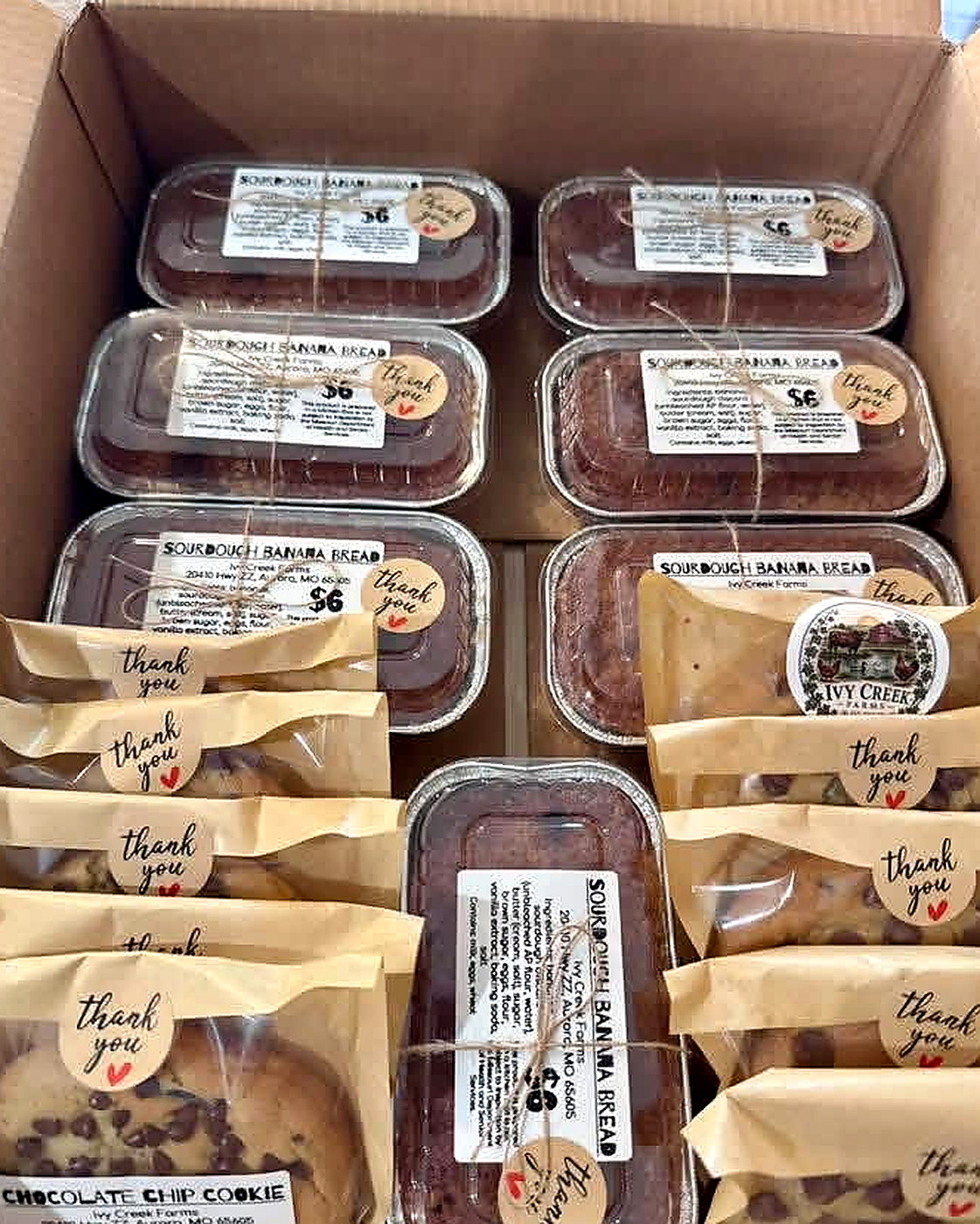 Boxes of homemade sourdough banana bread and chocolate chip cookies ready for orders